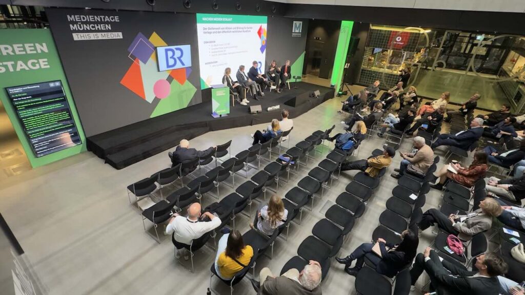 Live AI translation captions projected on the main stage screen at Medientage Munich 2024